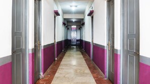 A long hallway with doors on both sides, leading to a room at the end.