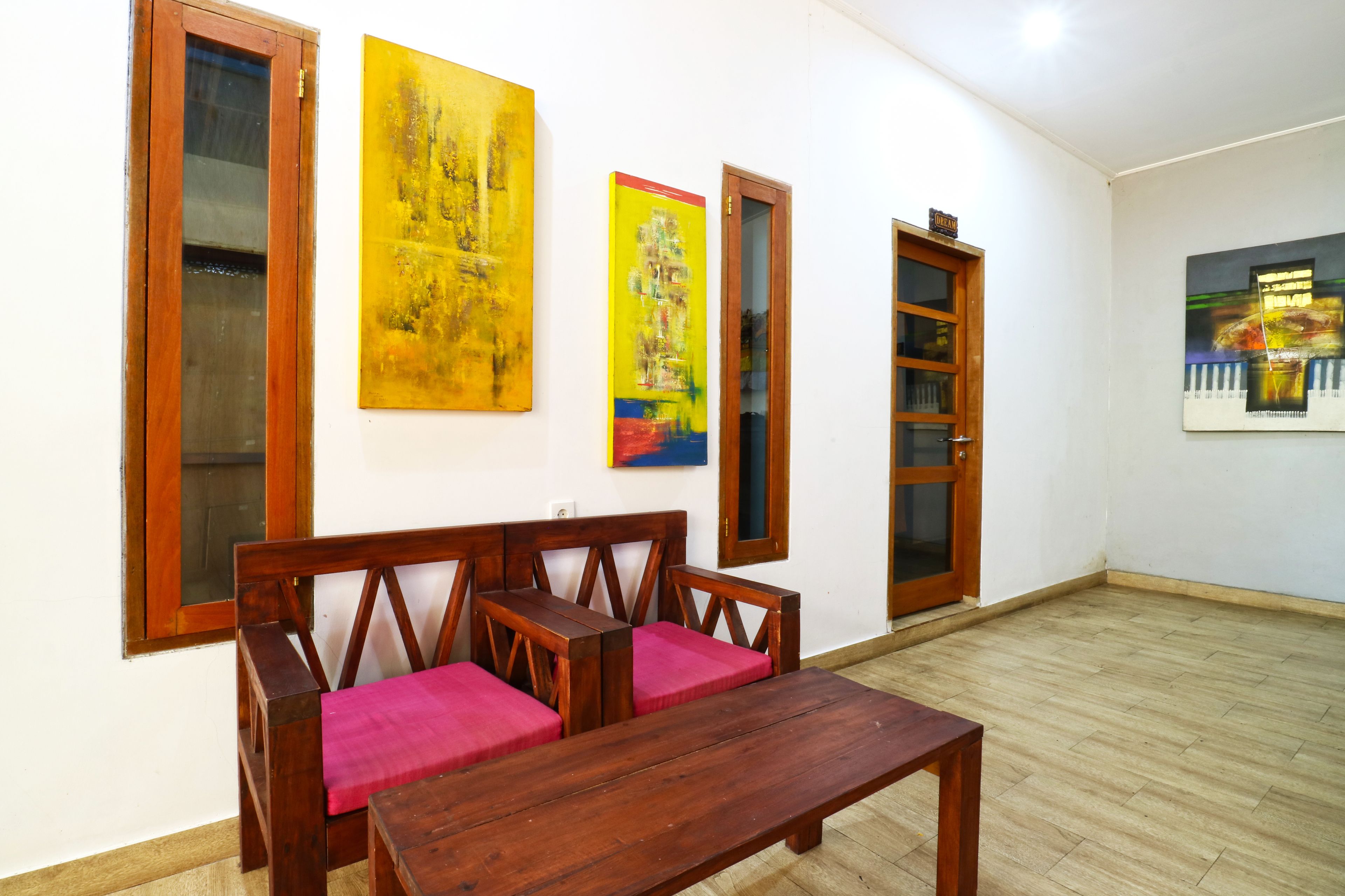 A room with a wooden bench, a small table, and a bookshelf.