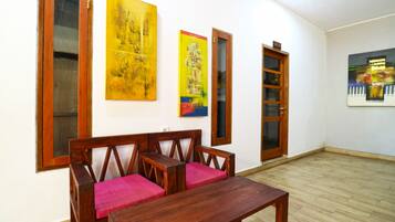 A room with a wooden bench, a small table, and a bookshelf.