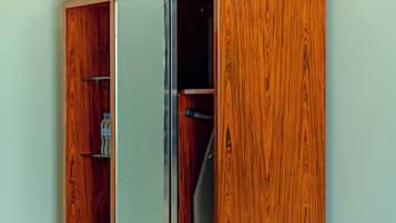 A wardrobe with a mirror, a hanging space, and a bench.