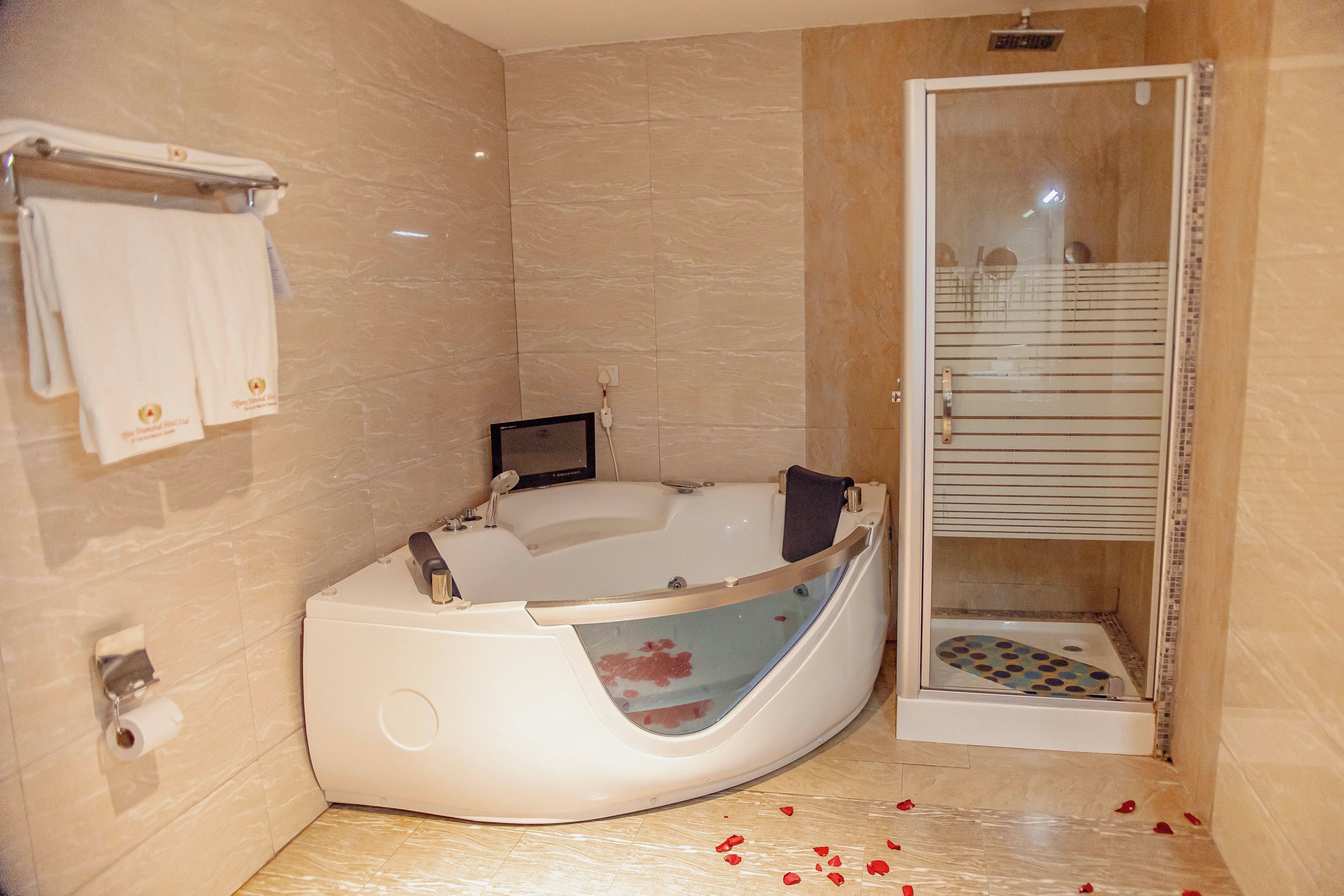 Un bagno moderno con una vasca da bagno indipendente, uno spazio doccia in vetro e un portasciugamani a muro.