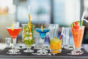 Diversitat de còctels colorits sobre una sovint de bar, amb un fons desenfocat.