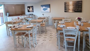 A dining area with multiple tables and chairs, equipped with table settings and decorative vases. - Summer Wine Friendly Resort (Corfu)