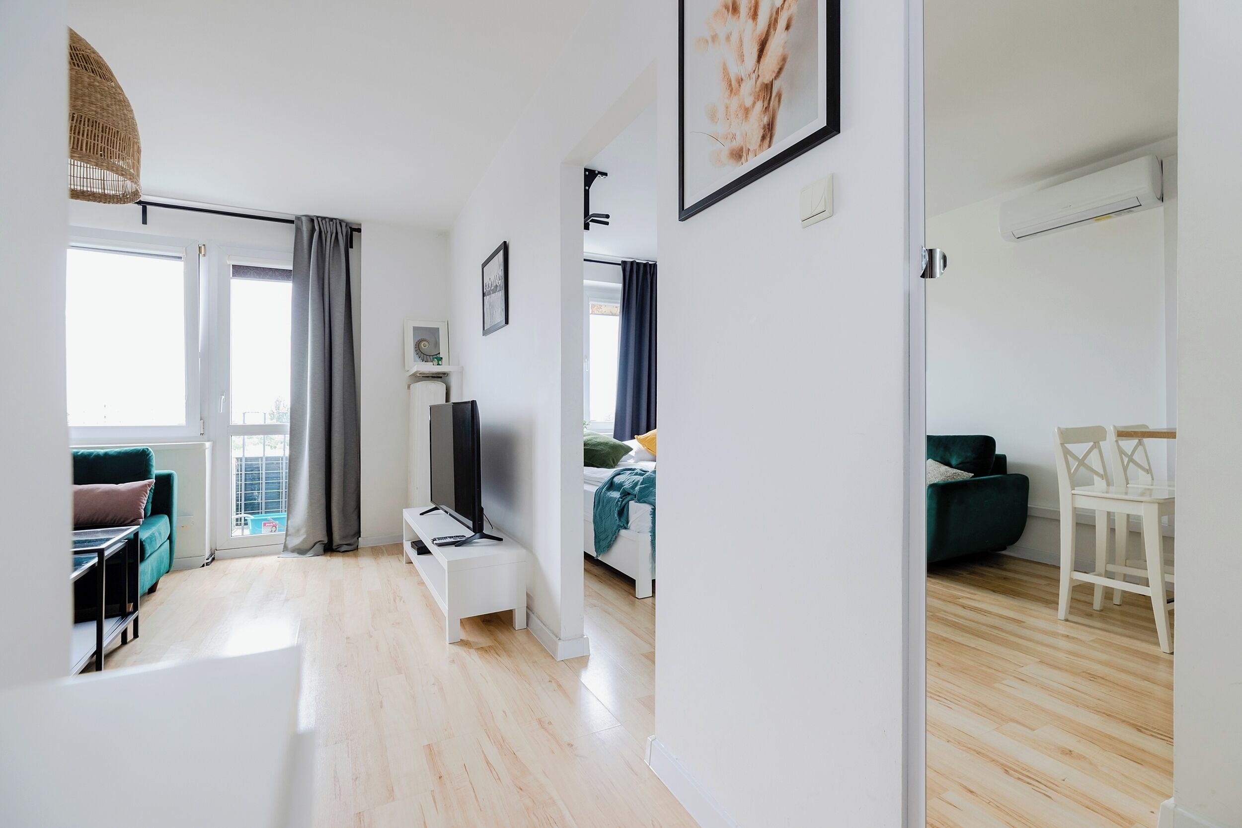 A modern apartment with a living area, a dining space, and a bedroom.