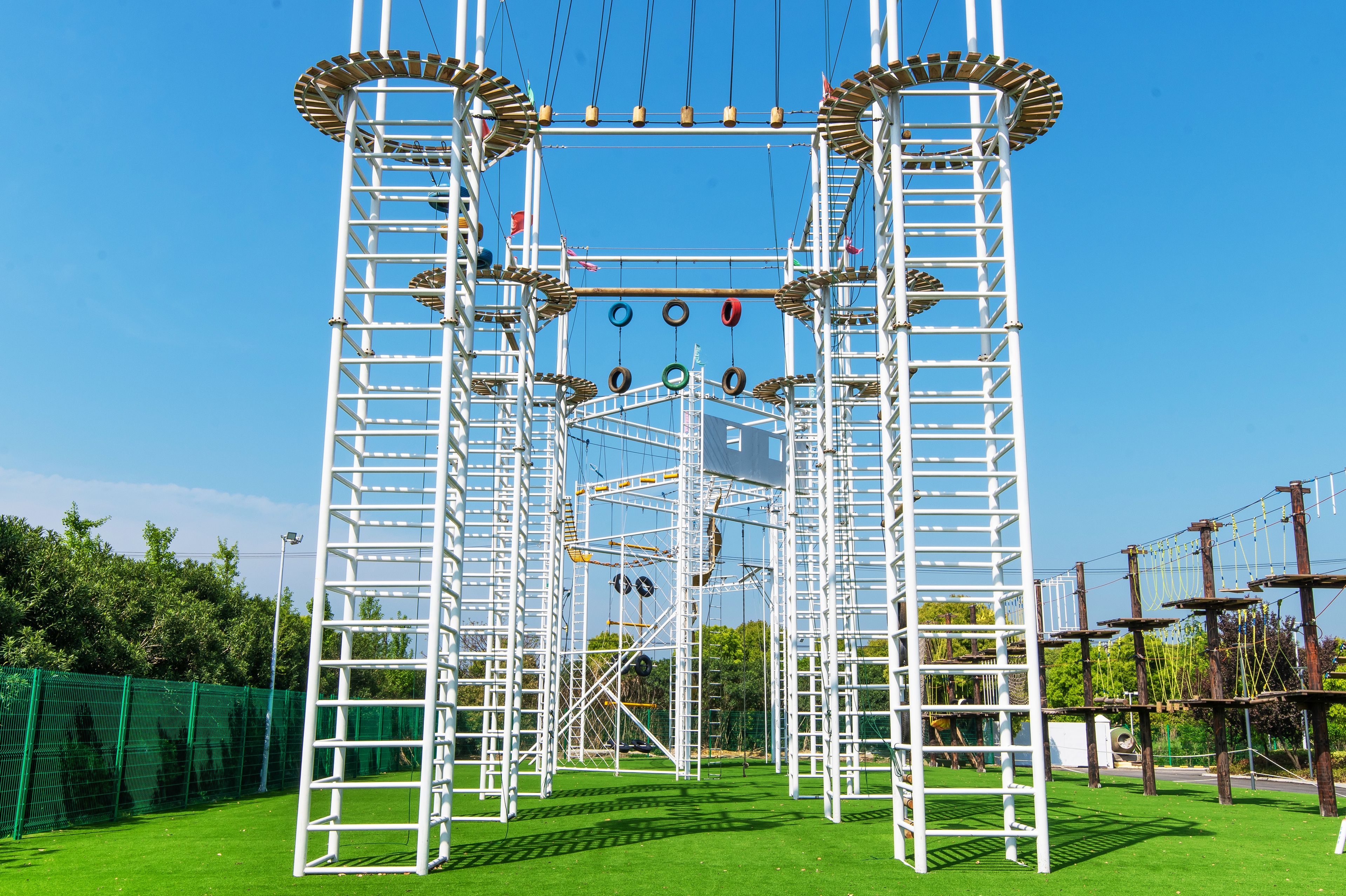 A metal climbing structure with multiple ladders and ropes.