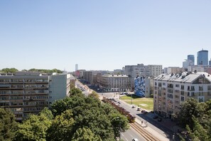 Une vue urbaine comprenant une ligne de tramway, des bâtiments et des arbres.