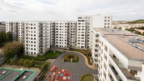 A high-rise residential building with multiple balconies, a rooftop garden, and a playground area. - ShortStayPoland Krakowska - B65 (Warsaw)