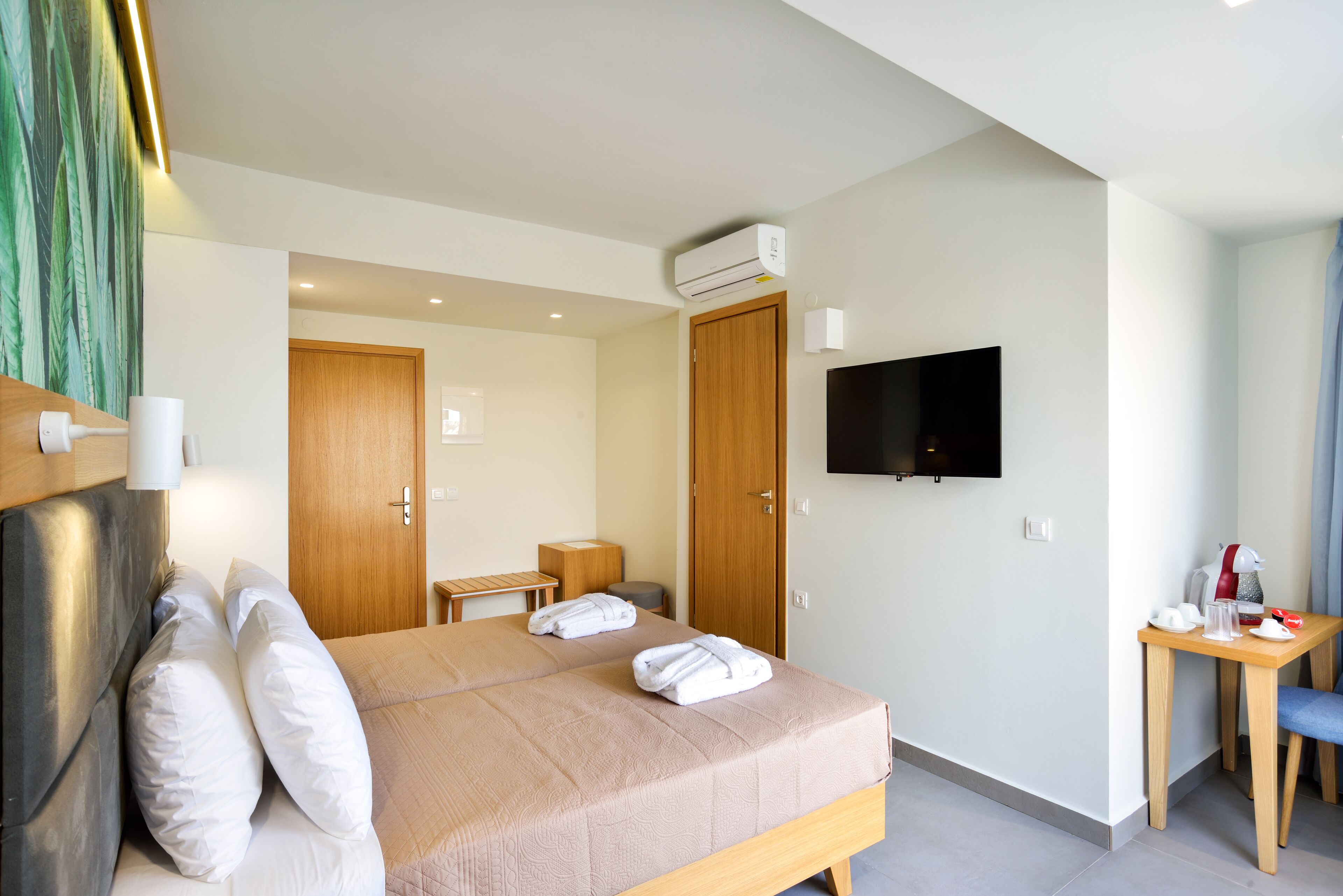 A hotel room with a bed, a TV, a desk, and a chair.