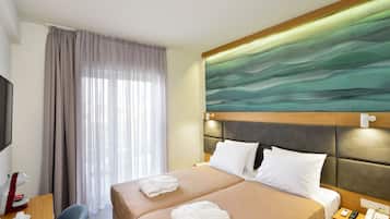 A hotel room with a bed, bedside table, and a television.
