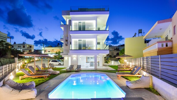 A modern multi-story building with a swimming pool in the foreground.