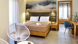 A modern hotel room with a large bed, two bedside tables, a desk, and a chair.