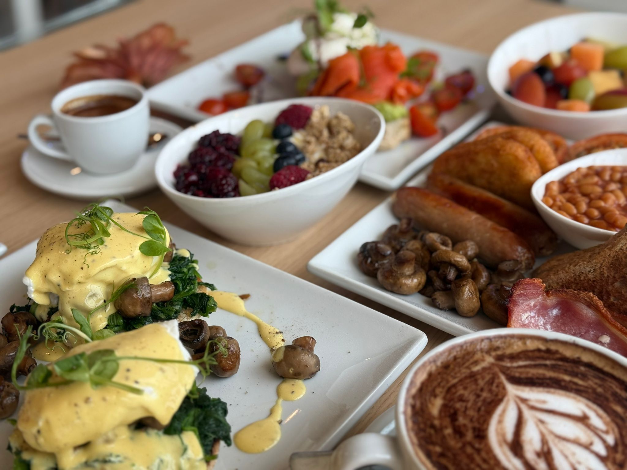 Um buffet de café da manhã com diversos pratos, incluindo ovos, cogumelos e feijão.