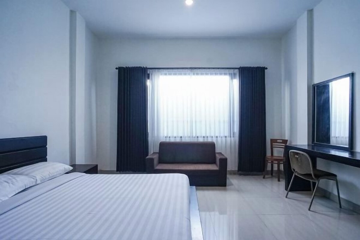 Een hotelkamer met een bed, een bank, een bureau en een stoel.