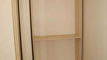 A view of a room with a wooden door and a light-colored wall.