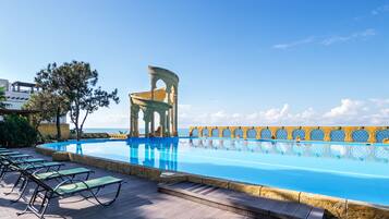 Una piscina cubierta, una piscina al aire libre de temporada, sombrillas