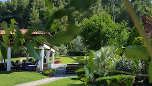 A well-maintained garden with a clear pathway, a gazebo, and lush greenery.