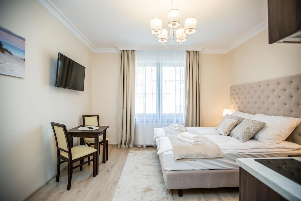 Ein Hotelzimmer mit einem Bett, einem Schreibtisch und einem Fernseher an der Wand.