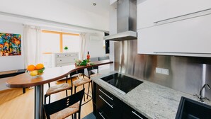 Eine moderne Küche mit einer zentralen Kochinsel, Edelstahlgeräten und einem Essbereich mit Blick.