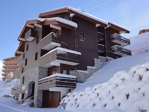 Um hotel com várias andares, varandas e fachada de pedra.