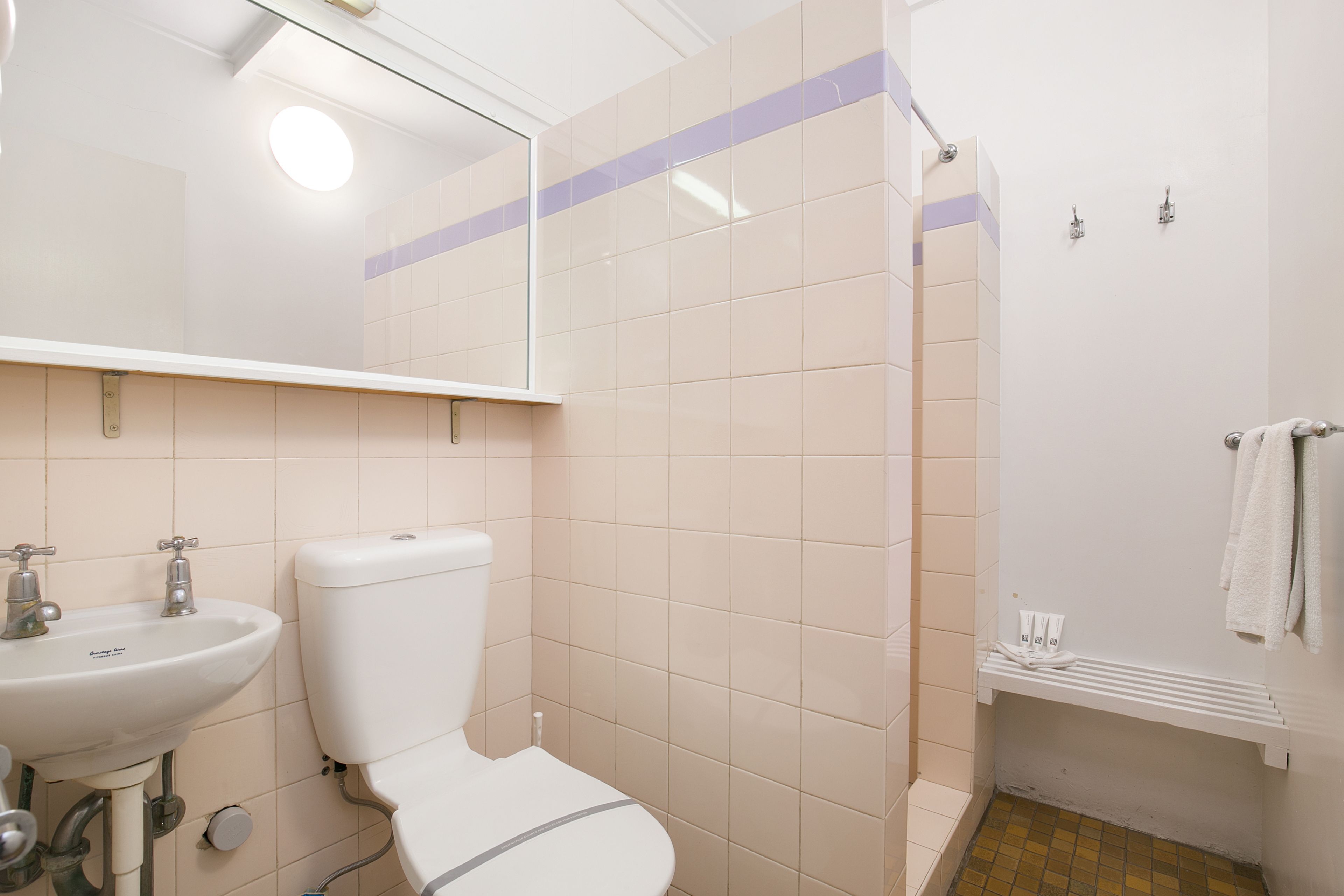 A bathroom with a toilet, sink, and shower.