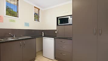 A compact kitchen with a dishwasher, a microwave, and a sink.