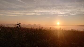 Amanecer sobre un campo con una silla al frente.