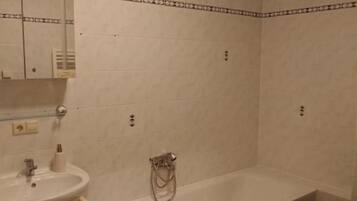 Un baño con bañera, lavamanos y espejo.