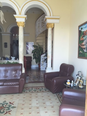 Un salon spacieux doté d’une grande fenêtre, d’une cheminée et d’un escalier menant à l’étage supérieur.
