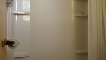 A bathroom with a shower, toilet, and a towel rack.
