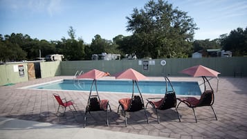 Een buitenzwembad, parasols voor strand/zwembad