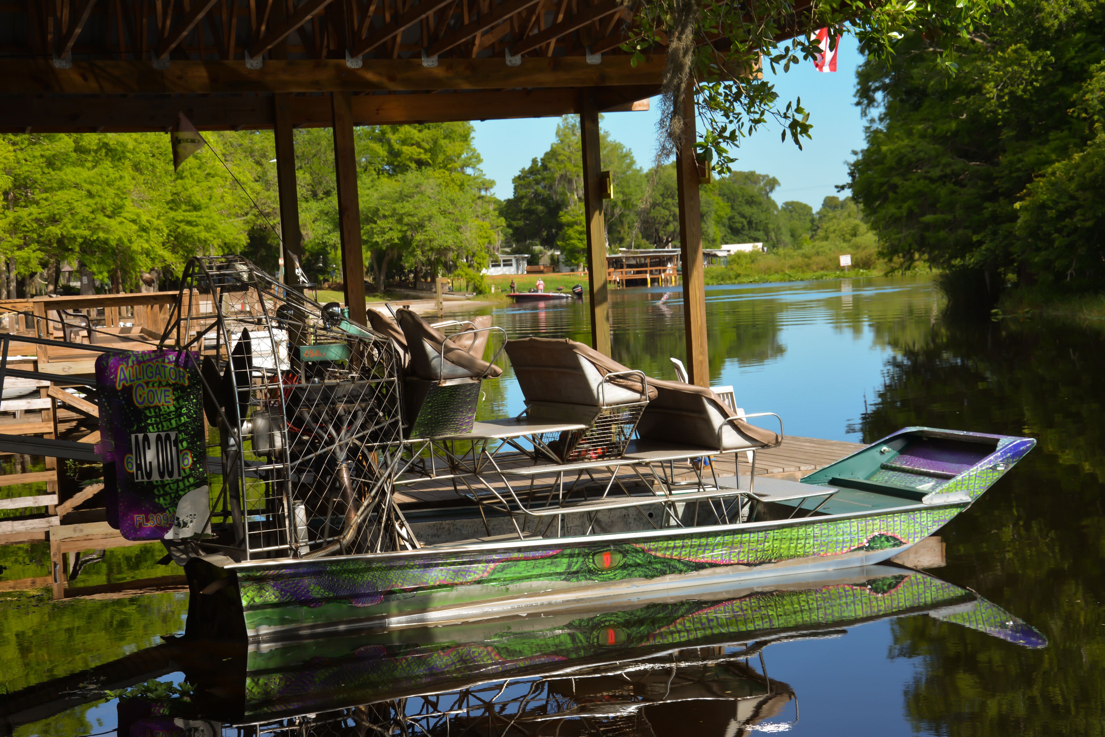 A boat docked at a pier with a covered seating area and a view of the water.