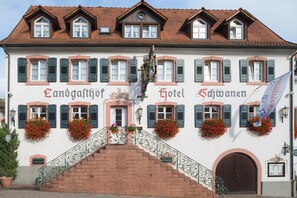 A traditional European hotel with a central entrance, multiple windows with shutters, and flower boxes. - Flair Hotel Schwanen (Bad Bellingen)