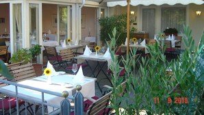 An outdoor dining area with tables, chairs, and umbrellas. - Flair Hotel Schwanen (Bad Bellingen)