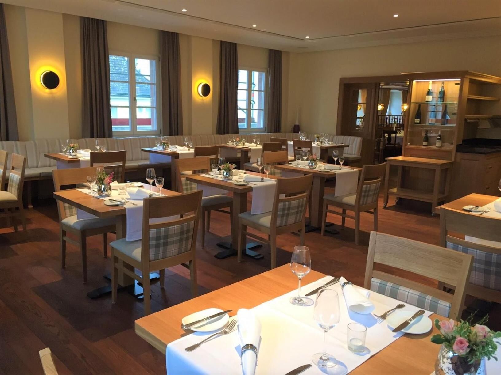 A restaurant with multiple dining tables, chairs, and a bar area.