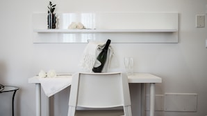 A white desk with a chair, a bottle of champagne, and two glasses on it. - Tenuta Vigna Del Noce (Corato)