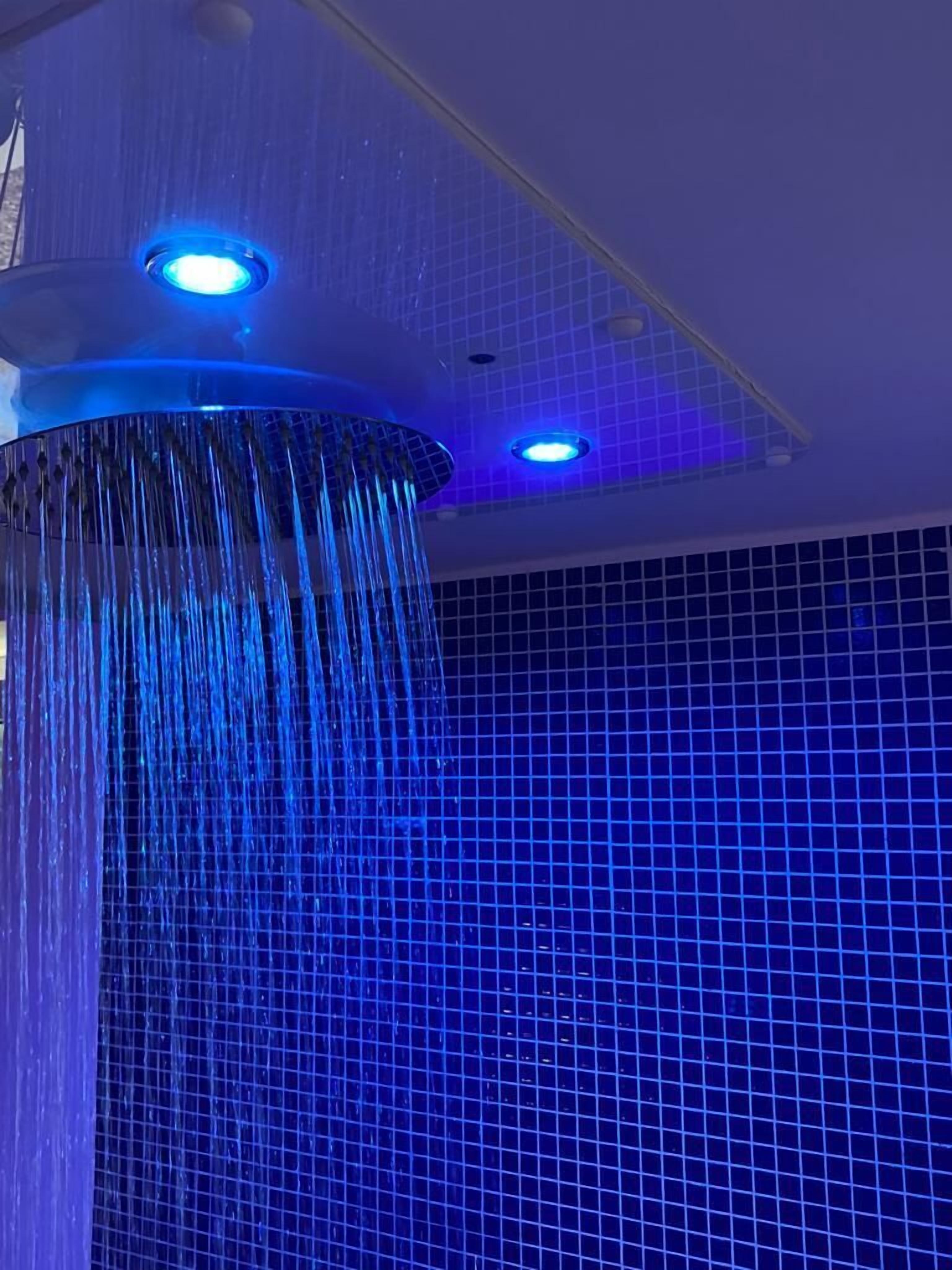 Ducha con diseño curvo e iluminación azul.