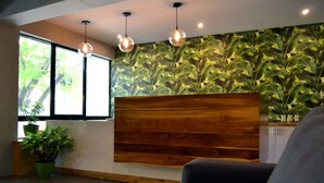 Un interior moderno con un mostrador de recepción de madera, plantas en macetas e iluminación colgante.