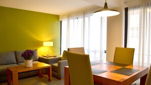 Una sala de estar moderna con una mesa de comedor de madera, sillas amarillas, un sofá y una lámpara.