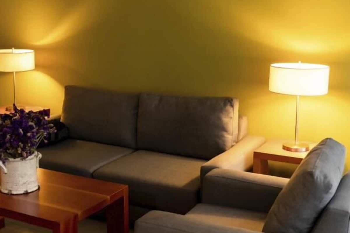 Un soggiorno con un divano, un tavolino e due lampade.