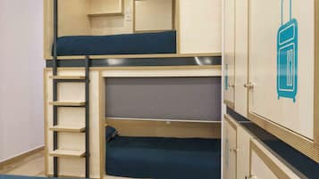 Une chambre avec un lit superposé, une échelle, une armoire et un pictogramme représentant une salle de bain sur le mur.