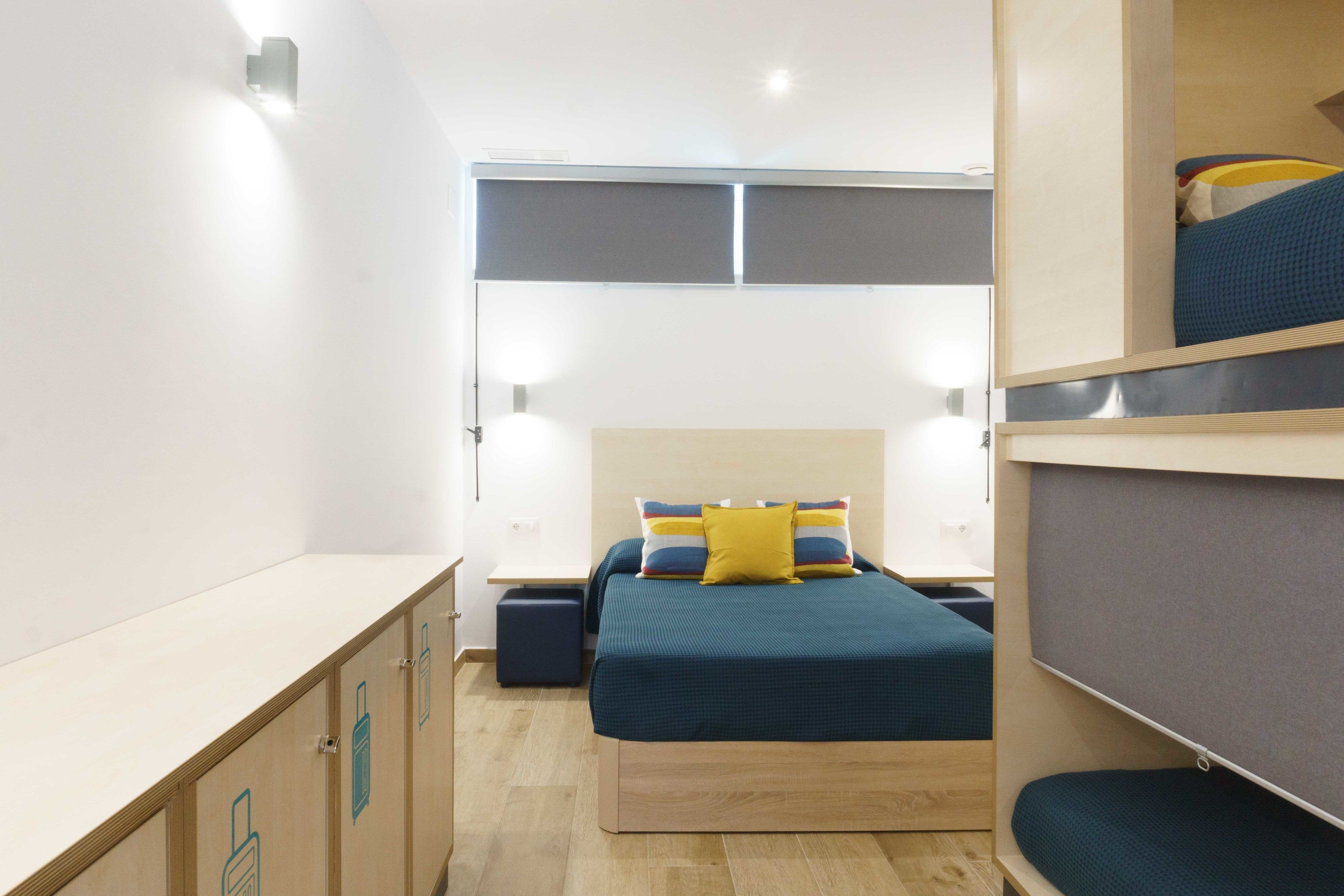 A compact room with a bed, bedside tables, and a wardrobe.