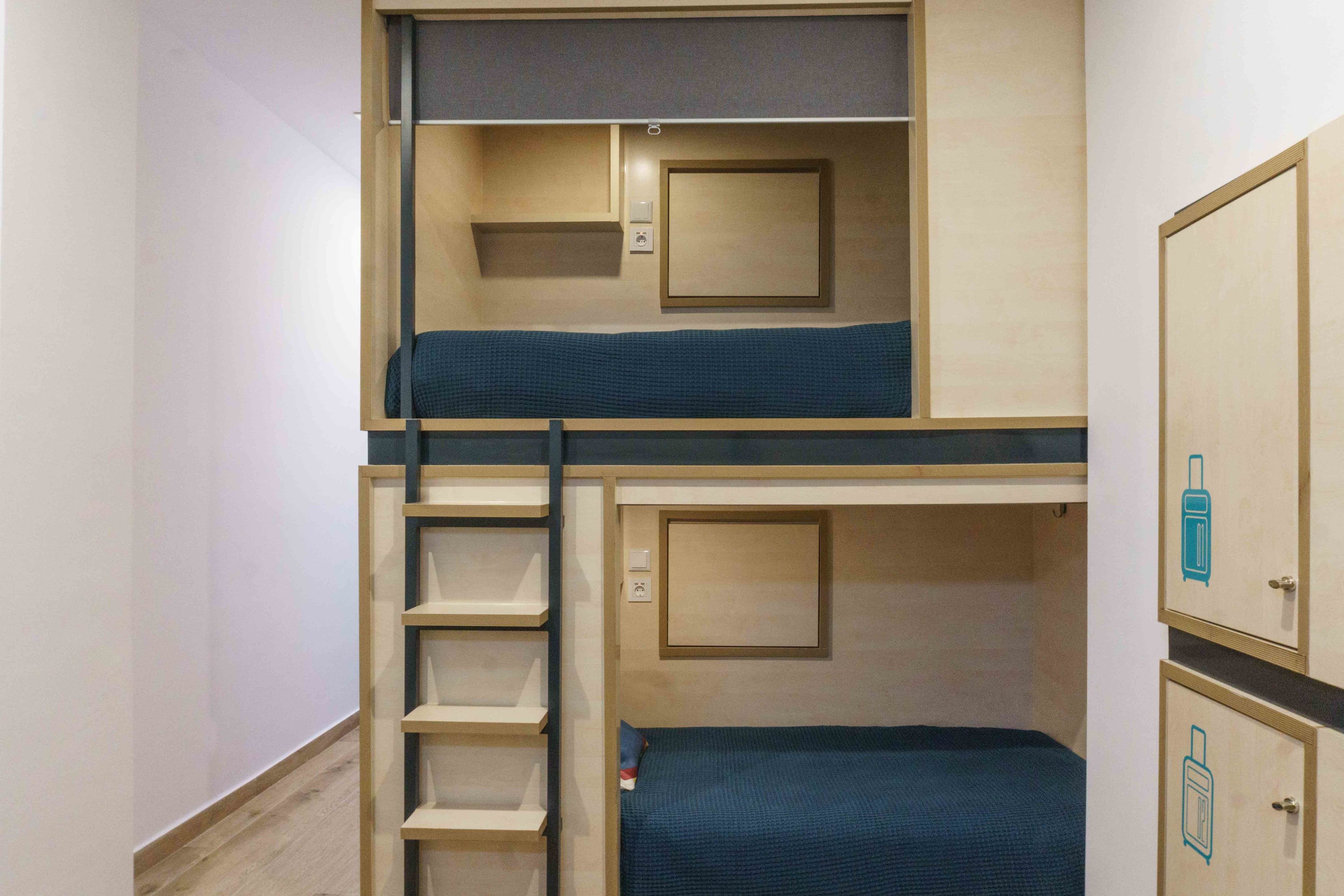Habitació amb literes, escriptori i armari.