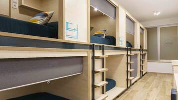 Habitación con literas, estanterías empotradas y zona de escritorio.