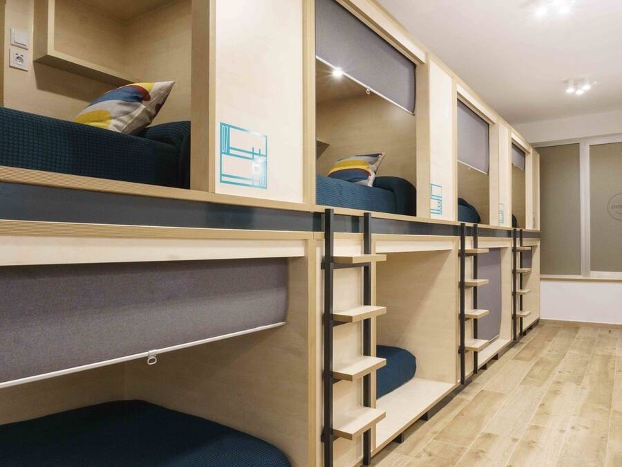 Habitación con literas, estanterías empotradas y zona de escritorio.