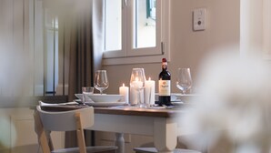 A dining table with candles, wine glasses, and a bottle of wine.