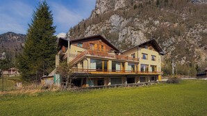 A two-story chalet with a balcony, set against a mountainous backdrop. -  Miravalle Supersport Hotel (Forni Avoltri)