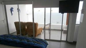 A bedroom with a bed, a chair, and a TV.