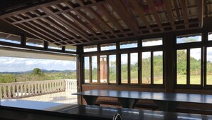 Cuina amb rentapelats, finestra amb vista a un balcó i paisatge de verdura i muntanyes.