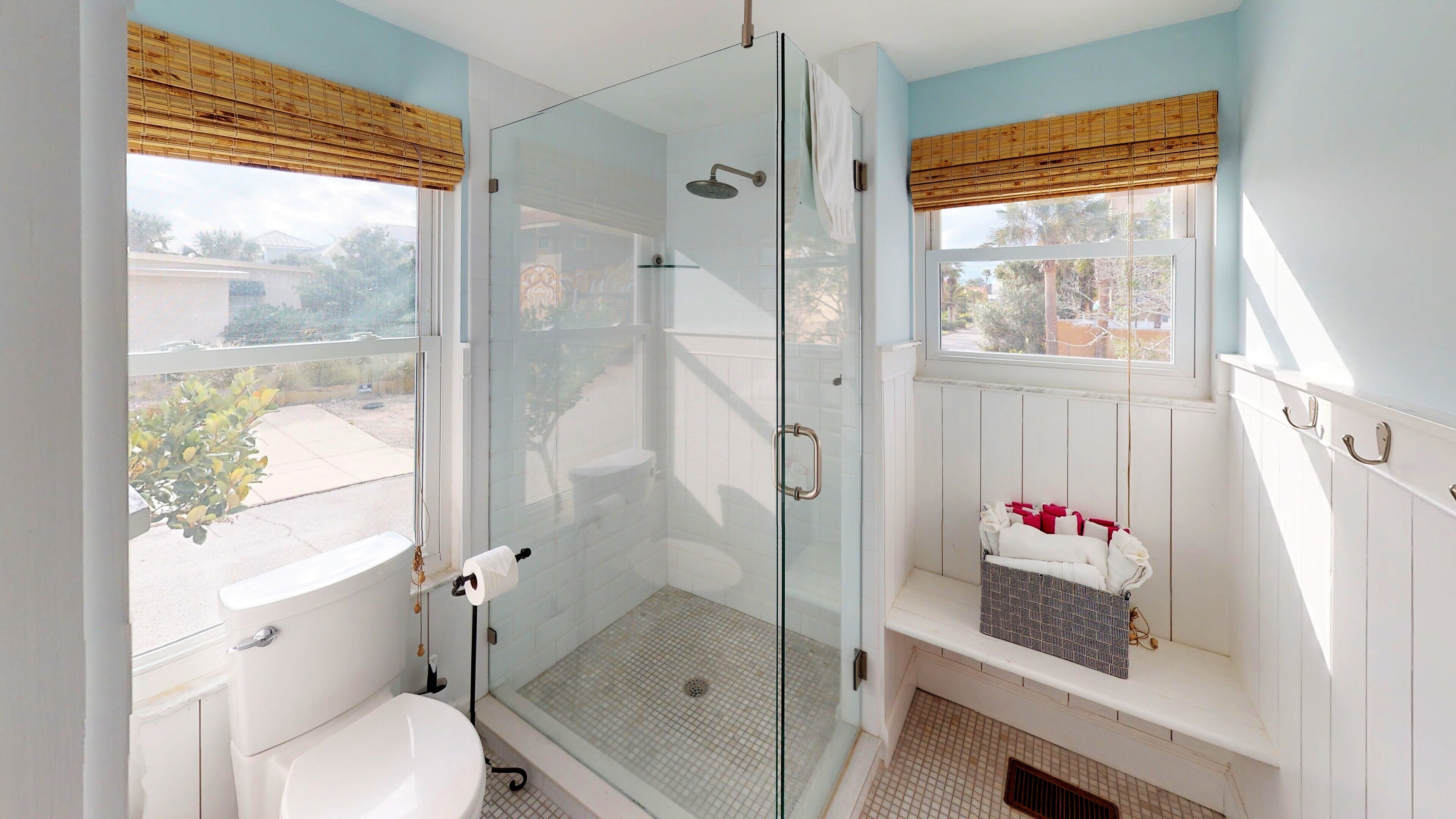 Une salle de bain avec une douche à parois de verre, des toilettes et un meuble-lavabo avec un porte-serviettes.