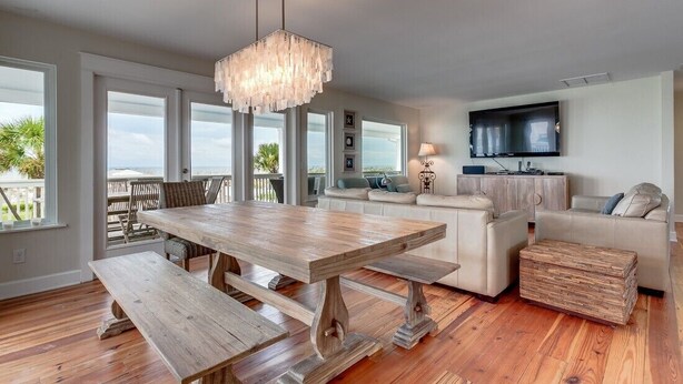 Un amplio espacio de estar con una mesa de comedor de madera, un sofá y una televisión.